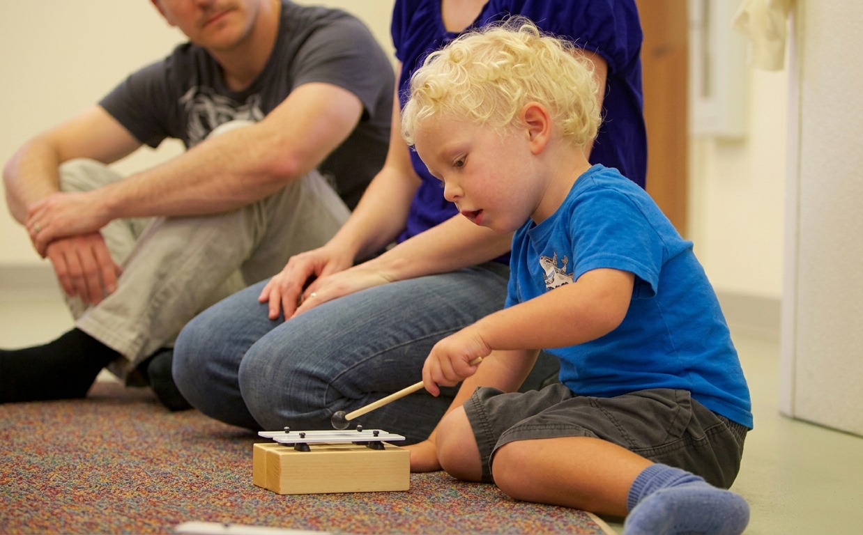 Parent and child laughing during a Music Together class